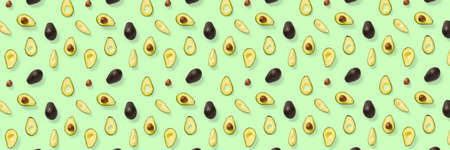 Avocado banner. Background made from isolated Avocado pieces on green background. Flat lay of fresh ripe avocados and avacado piecesの写真素材
