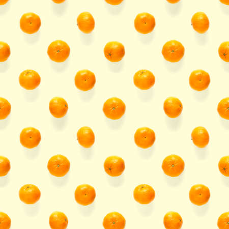 Fresh mandarin Seamles pattern. Ripe fruit tangerines seamless pattern. Fresh citrus isolated on yellow background pattern. Flat lay of Clementine. Mandarine modern tropical seamless background.の写真素材