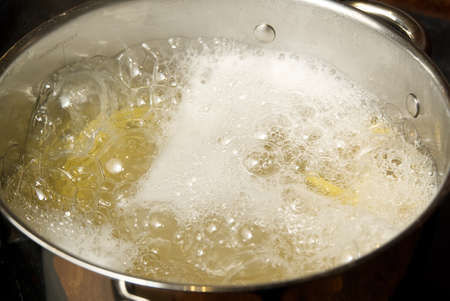 Boiling pasta spaghetti in pot. penne rigate pasta- Cooking pasta in boiling water. close up. Checking cooking quality pasta on forkの写真素材