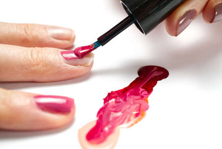 Manicure. Closeup shot of a woman hand polishing nails - manicure. Young caucasian woman receiving a french manicure. Nail technician manicure at nail salon.の写真素材