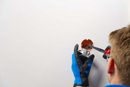 Man installing light switch after home renovation. Electrician installing light switch on painted wall with screwdriver.の写真素材