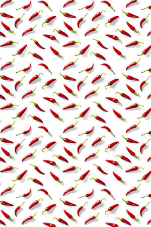 Creative background made of red chili or chilli on white backdrop. Minimal food backgroud. Red hot chilli peppers background, not patternの写真素材