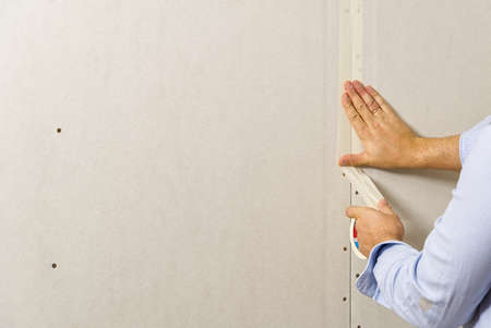 Painter glue the joints between the plasterboard, drywall sheets. close up with copy spaceの写真素材