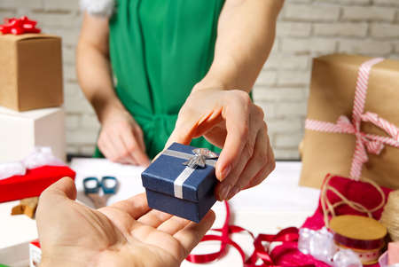 Female hands holding packed present for christmas Festive backdrop for holidays Birthday, Valentines...