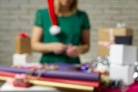 Defocused background. Gift wrapping for Christmas and New Year. Handmade. girl's hands with gift...