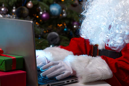 santa sitting behind laptop. Santa Claus in a lockdown sitting behind a laptop leads online communication.の写真素材