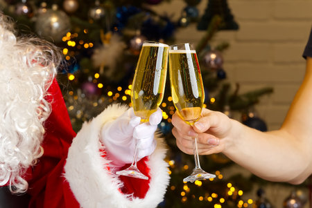 santa clinks glasses of champagne. clinking champagne glasses, celebrating Christmas or New Year togetherの写真素材
