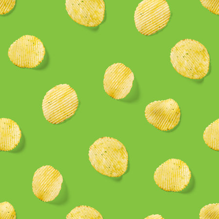 Seamless pattern made from Potato chips on green background flat lay. potato snack chips isolated Fast food banner.の写真素材