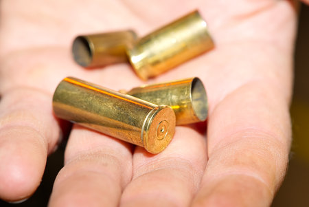 close-up of bronze cartridge cases on a hand in a shooting range or at a crime scene. crime concept