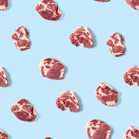 Seamless Pattern with raw pork meat slices on blue background, food patternの写真素材