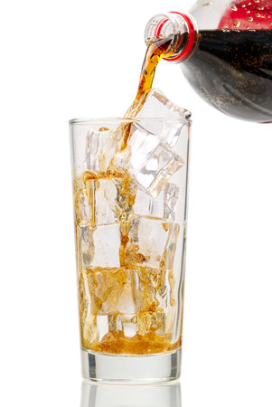 Pouring Cola to glass with ice cubes isolated on whiteの写真素材