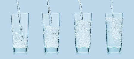 Pouring water. Pouring fresh clean drinking water to glass. Banner
