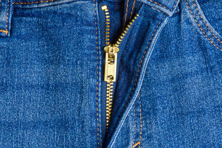 half unzippedblue zip on a of blue jeans. jeans macro texture background.