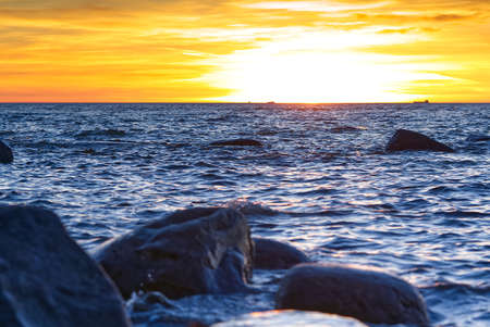Sunset at Baltic sea stone shore, in Estonia, Viimsi. View over Baltic sea with stones to beautiful sunset at horizonの写真素材