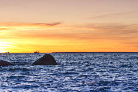 Sunset at Baltic sea stone shore, in Estonia, Viimsi. View over Baltic sea with stones to beautiful sunsetの写真素材