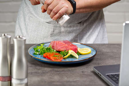 Cooking with notebook tuna steak in home kitchen.