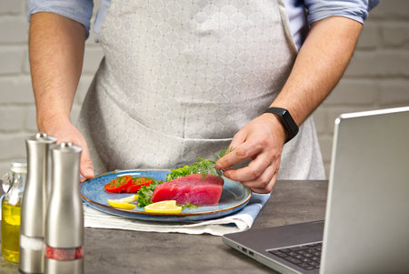 Cooking with notebook tuna steak in home kitchen.