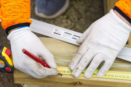 Carpenters hands in white gloves and tools for precise work