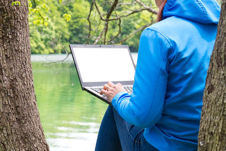 Work from anywhere. Remote freelancer work in nature. Young woman, female freelancer working with...