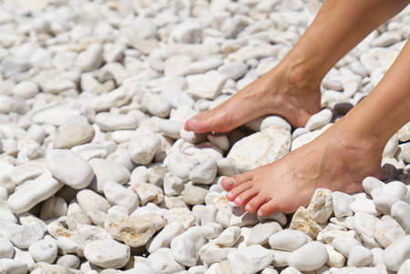 beautiful legs on a rocky beach. woman feet on front of sea rocky beach. Rest, vacation, love...