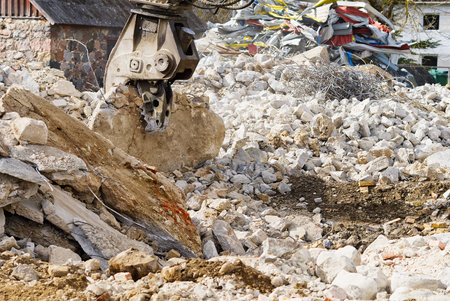 Old stone building demolition with excavator. Excavator working on demolition of the commercial building. construction equipment in operation, reconstruction concept. Demolition construction workの写真素材