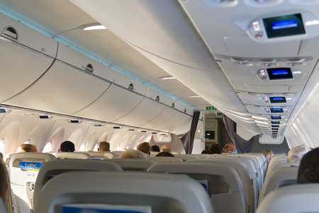 Estonia, Tallinn, 31.06.2021 - Modern interior of aircraft Airbus A220-300 Airbaltic with passangers flying from Tallinn to Riga. Economy class of flight.のeditorial素材