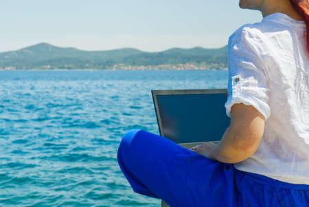 Lifestyle freelance woman using laptop working and relax on the beach. Business and Summer Concept. remote office concept.の写真素材
