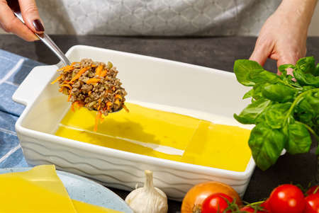 Woman preparing meat lasagna in kitchen. Italian food. lasagna recipeの写真素材