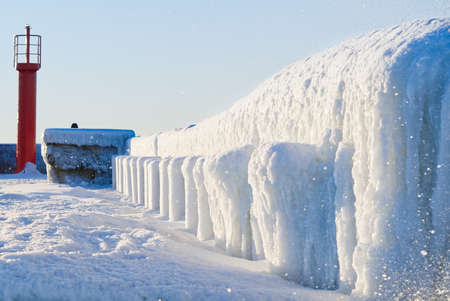 Winter on shore of the Baltic Sea. Lighthouse in ice. Baltic Sea and frozen pier in winter, Estonia, Tallinnの写真素材