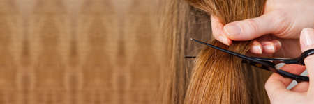 Woman hair care. Hairdresser making hairstyle to young girl in kid beauty salon.の写真素材