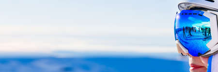 Portrait of woman in alps. woman in ski goggles at the ski resort. woman in mountain goggles. reflection in ski gogglesの写真素材