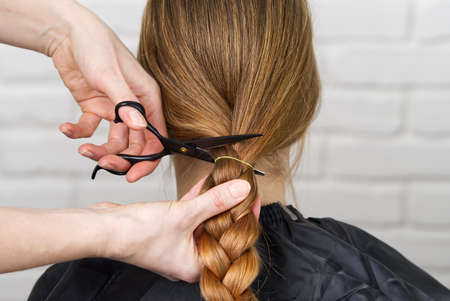 woman hair donations for people with cancer. cutting off long braided hair. Concept of hair...