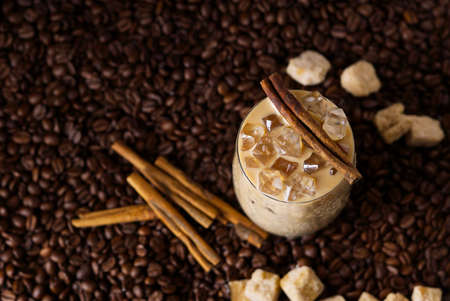 Iced latte coffee. Cup of Iced latte coffee, milk tea on dark coffee seeds background. Could Coffee...