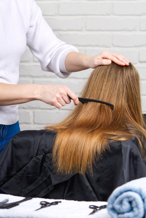 Beautiful girl with long hair. creating a hairstyle for a young unrecognizable girl. Hair styling process.の写真素材