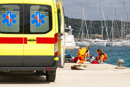 ambulance workers provide first aid to a person in a yacht port. heat stroke in the sun.の写真素材