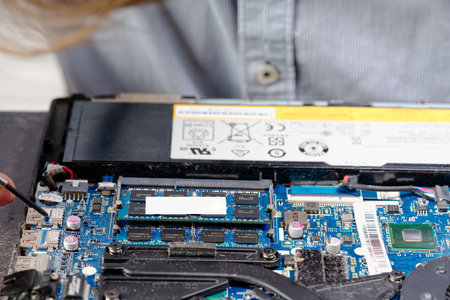 Notebook repair. Man disassembles a laptop. Removes the keyboard. Computer service and repair concept. Laptop disassembling in repair shop, close-up.の写真素材