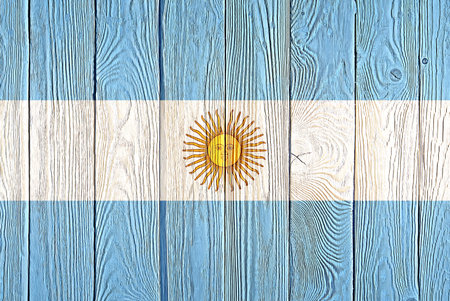 Argentina flag painted on old wood plank background. Brushed natural light knotted wooden board texture. Wooden texture background flag of Argentina.の写真素材