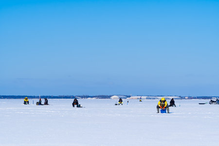 Ice Fishing. Winter fishing on ice at sea, Estonia.の写真素材