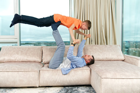 Father and son having fun at home. Parents spending quality time with childrensの写真素材