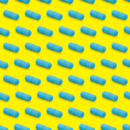 Gel capsule seamless pattern. Blue capsule drug, pharmacy concept. food supplement, on yellowの写真素材