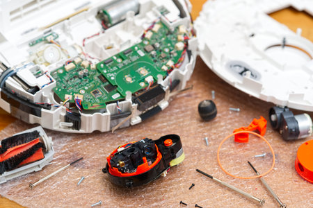 Serviceman, Repairman, maintenance on robotic vacuum cleaner. Repairing robot cleaner. Electronics...