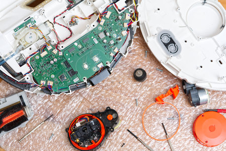 Serviceman, Repairman, maintenance on robotic vacuum cleaner. Repairing robot cleaner.の写真素材