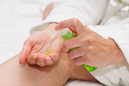 Young woman applying aloe vera to hand. Woman hand with jojoba oil anti aging antioxidant.の写真素材