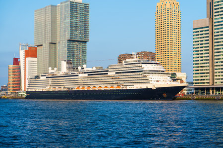 Big cruise ship parked in center of rotterdam. View of the skyscrapers of rotterdam on a sunny dayの写真素材