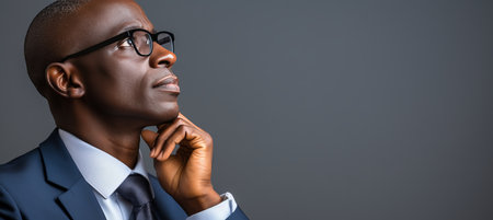 Senior african american businessman in formal wear and glasses on grey background with copy spaceの素材