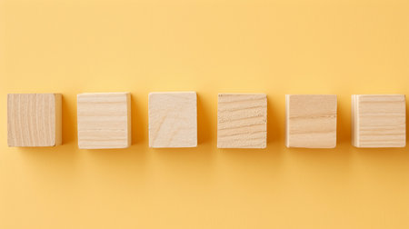 Row of small wooden blocks with empty space for text placement on a solid textured backgroundの素材