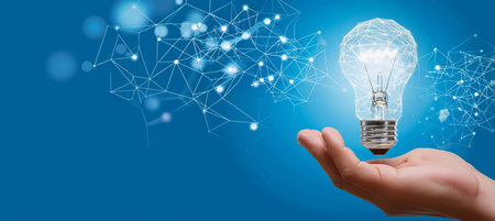 hand holding electric bulb on dark blue magical background with empty space for textの素材