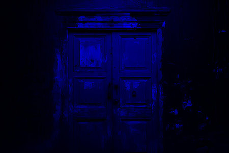 Close up of weathered wooden door with vibrant peeling paint in bright natural lightの素材