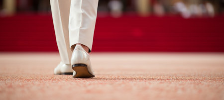 Elegant man in white fashion dress and high heels on red carpet at movie premiere eventの素材