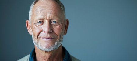 Smiling middle aged man in studio bright shot with copy space on left side for advertisingの素材
